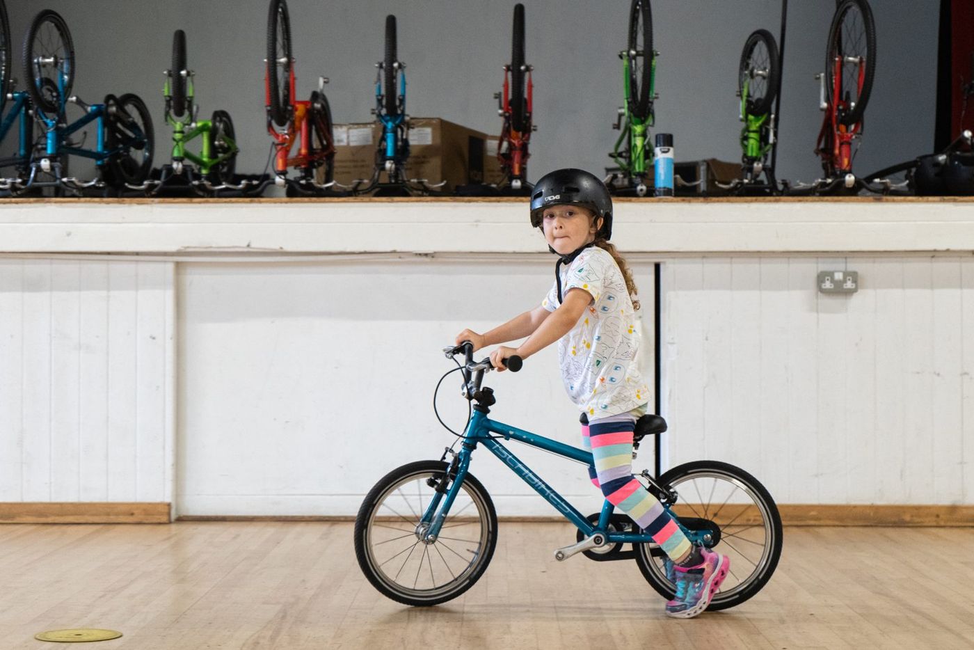 A girl cycling on a blue bike